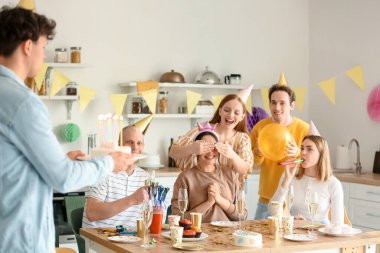 Genç adam partideki arkadaşına doğum günü pastası getiriyor.