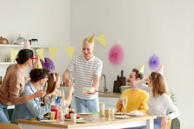 Bir grup genç arkadaş mutfakta doğum gününü kutluyor.