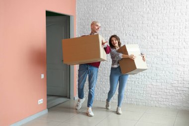 Taşındığı gün odada kutuları olan genç bir çift.