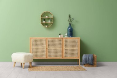 Yeşil duvarın yanında çekmeceler ve paspaslar.