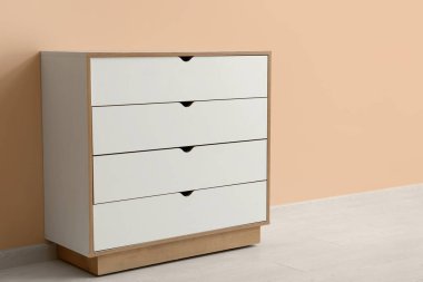 Bej duvarın yanındaki açık tahta çekmeceler.