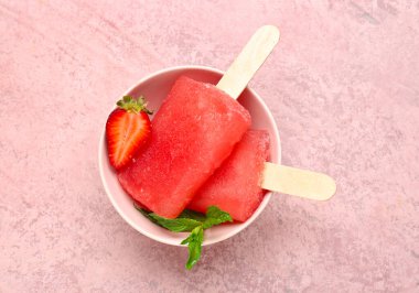 Arkaplanda çilekli dondurma, taze böğürtlen ve nane yaprağı var.