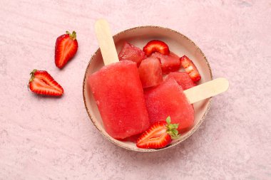 Çilekli dondurma kasesi ve pembe grunge arka planda taze böğürtlen.