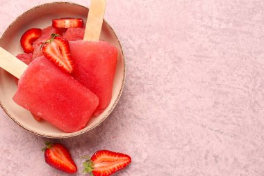 Çilekli dondurma kasesi ve pembe grunge arka planda taze böğürtlen.