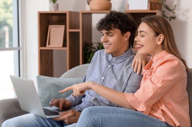 Evde bilgisayar alışverişi yapan genç bir çift.