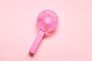 Pembe arka planda taşınabilir elektrikli fan.