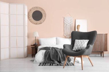 Modern yatak odası. Katlanan ekran, koltuk ve yatak.