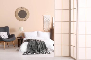 Modern yatak odası. Katlanan ekran, koltuk ve yatak.