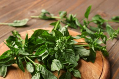 Tahta kesme tahtası ahşap arka planda taze fesleğen, yakın plan