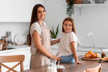 Küçük kızı mutfaktayken mutlu bir anne.