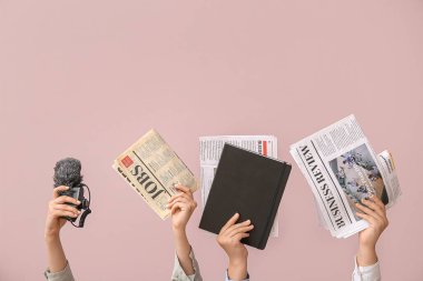 Farklı gazetelere, not defterine ve mikrofona sahip kadın elleri