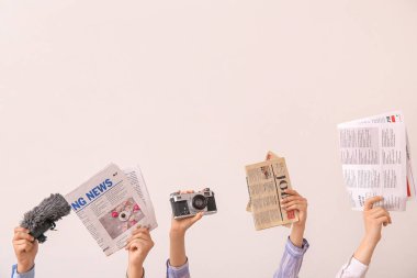 Gazeteli kadın eller, fotoğraf makinesi ve arka planda mikrofon.