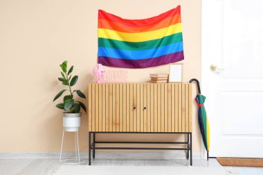 Salonun içinde asılı LGBT bayrağı, şemsiyesi ve çekmeceleri var.