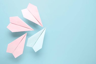 Mavi arkaplanda renkli origami kağıt uçaklar