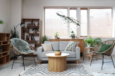 Rahat kanepesi, koltuğu ve masası olan modern oturma odası.