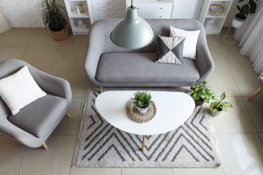 Oturma odasında rahat bir koltuk, kanepe ve masa.