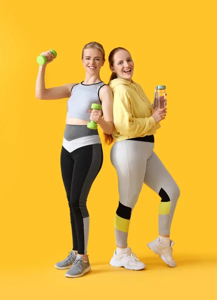 노란색 배경에 덤벨과 스포츠 여성의 초상화 — 스톡 사진