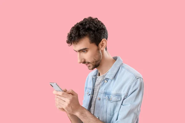 Όμορφος Νεαρός Άνδρας Που Χρησιμοποιεί Κινητό Τηλέφωνο Ροζ Φόντο — Φωτογραφία Αρχείου