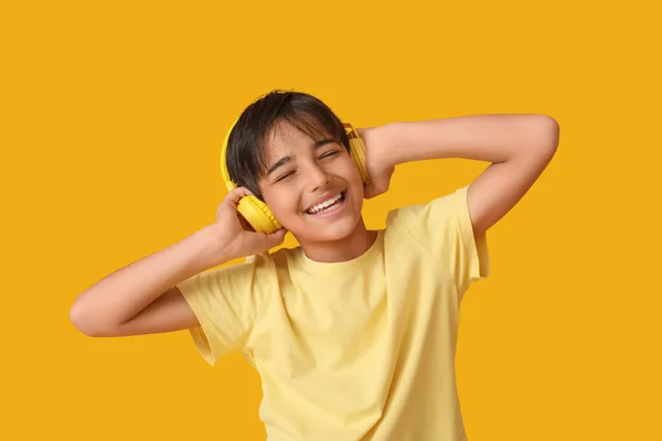 戴耳机听橙色背景音乐的小男孩 — 图库照片