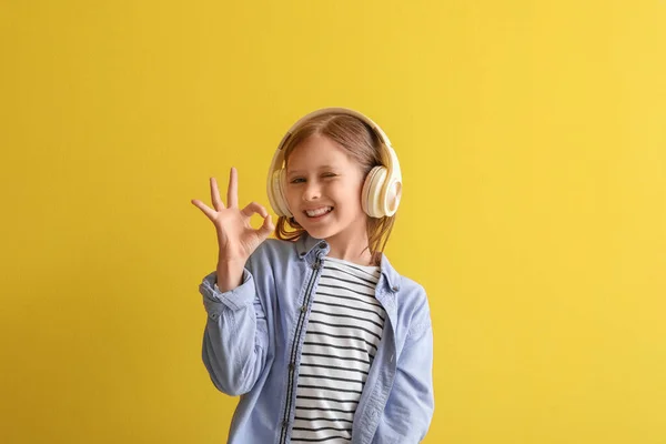 Kulaklıklı Küçük Kız Sarı Arka Planda Iyi Görünüyor — Stok fotoğraf
