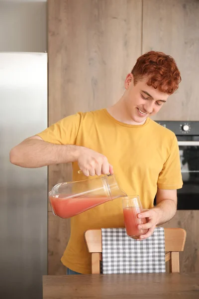 Young Redhead Man Pouring Juice Glass Kitchen — Stock Photo, Image