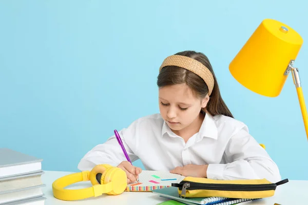 Kleines Mädchen Gibt Unterricht Tisch Auf Blauem Hintergrund — Stockfoto