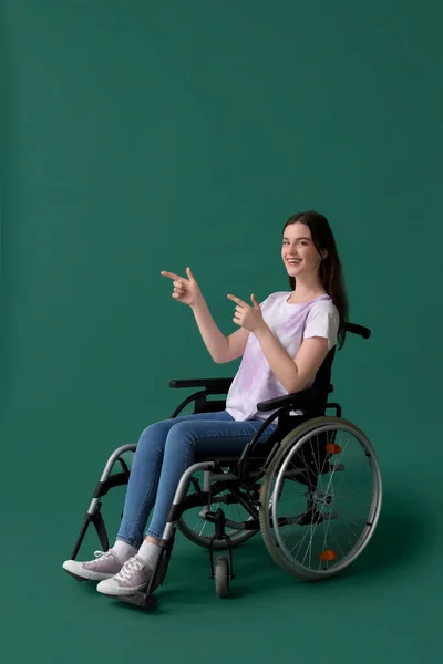 Молодая Женщина Инвалидной Коляске Указывает Зеленом Фоне — стоковое фото