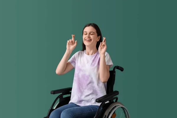 Молодая Женщина Инвалидной Коляске Скрещивает Пальцы Зеленом Фоне — стоковое фото