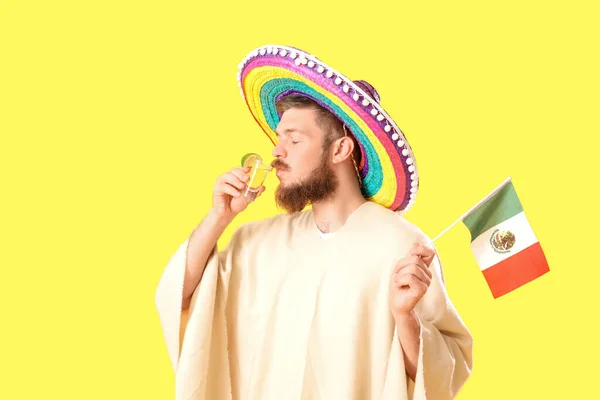 Bonito Jovem Sombrero Com Bandeira Mexicana Bebendo Tequila Fundo Amarelo — Fotografia de Stock