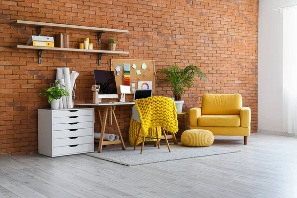Interior of office with designer\'s workplace and armchair