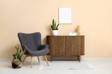 Rahat koltuğu ve renk duvarına yakın bitkileri olan modern oturma odasının şık bir iç mekanı.