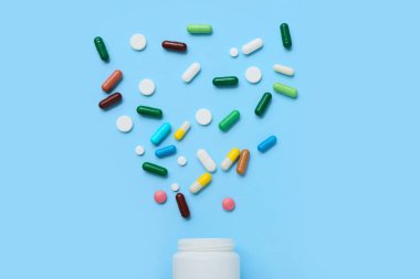 Renkli arka planda şişe ve farklı haplarla kompozisyon