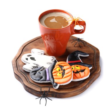 Beyaz arka planda Cadılar Bayramı kutlaması için lezzetli kurabiyeler ve bir fincan kahve.