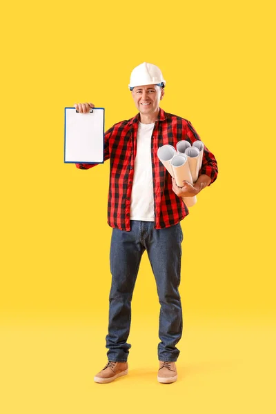 Sarı Arka Planda Kağıt Ruloları Olan Olgun Bir Işçi Şçi — Stok fotoğraf