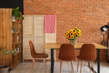 Modern mutfakta yemek masasında ayçiçekli vazo.