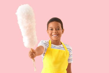 Pembe arka planda toz bezi olan küçük Afro-Amerikalı çocuk.