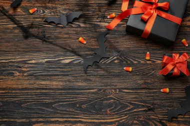 Hediye kutularıyla kompozisyon, lezzetli mısır şekerlemeleri ve ahşap arka planda Cadılar Bayramı dekoru.