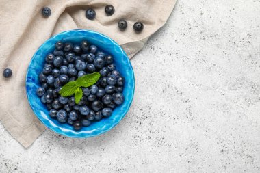 Taze yaban mersinli kase ve beyaz arka planda nane.