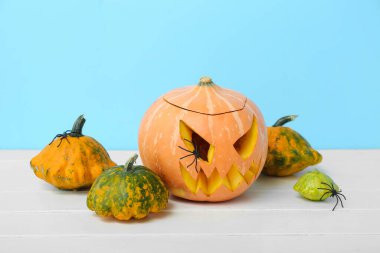 Hafif ahşap masaya oyulmuş Cadılar Bayramı balkabağı ve kabakları