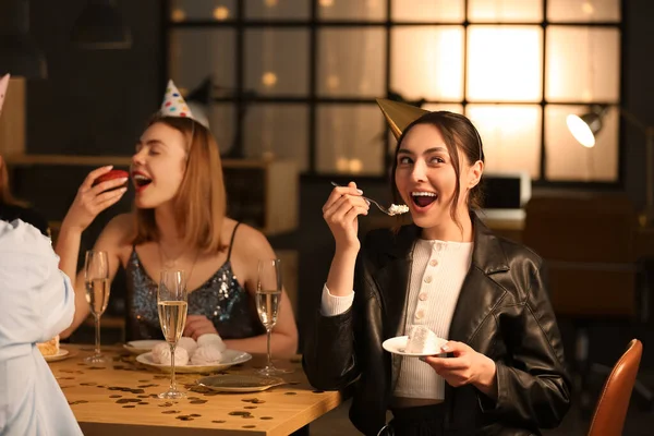 年轻女人晚上和朋友一起吃生日蛋糕 — 图库照片