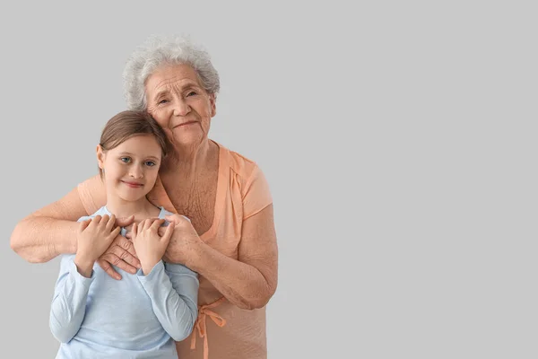 Little Girl Her Grandmother Hugging Grey Background — Stock Photo, Image