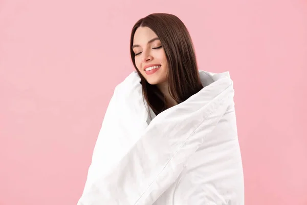 ピンクの背景に柔らかい毛布を持つ若い女性 — ストック写真