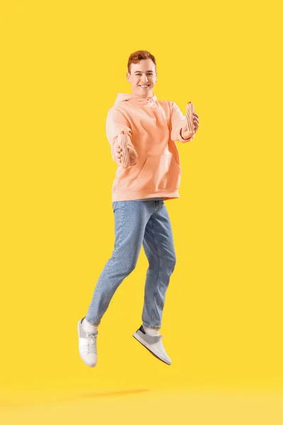 Jumping Junger Mann Mit Leckeren Hot Dogs Auf Gelbem Hintergrund — Stockfoto