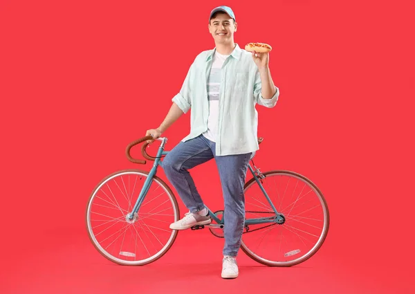 Giovane Con Gustoso Hot Dog Bicicletta Sfondo Rosso — Foto Stock