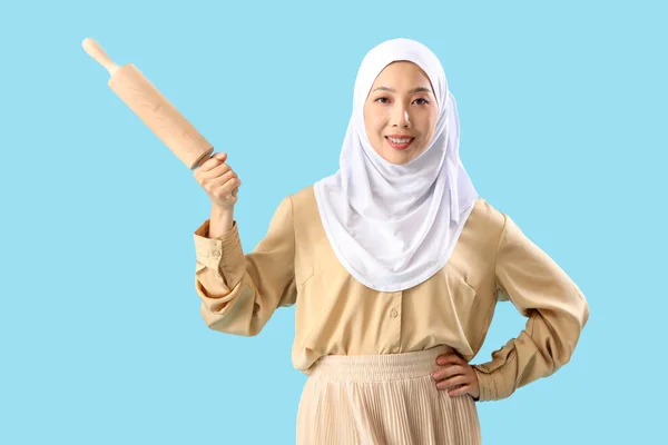 Junge Asiatin Hijab Mit Nudelholz Auf Blauem Hintergrund — Stockfoto
