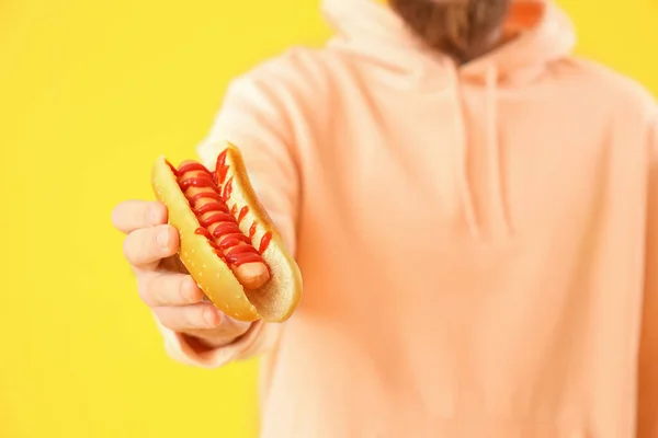 Mężczyzna Smacznym Hot Dogiem Żółtym Tle Zbliżenie — Zdjęcie stockowe