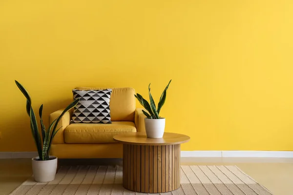 Wygodny Fotel Stolik Kawowy Rośliny Domowe Pobliżu Żółtej Ściany — Zdjęcie stockowe