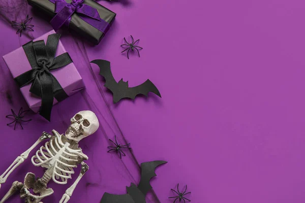 Kompozice Dárkovými Krabicemi Kostrou Halloweenským Dekorem Fialovém Pozadí — Stock fotografie
