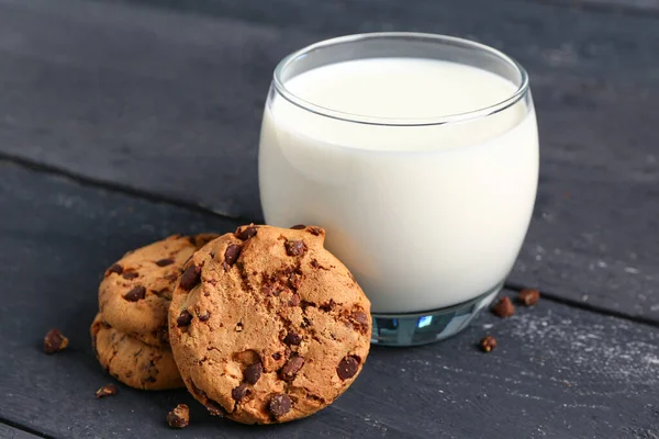 Glas Milch Und Leckere Kekse Mit Schokoladenstücken Auf Schwarzem Holzhintergrund — Stockfoto