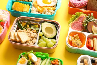 Sarı arka planda farklı lezzetli yemekleri olan bir sürü beslenme çantası.